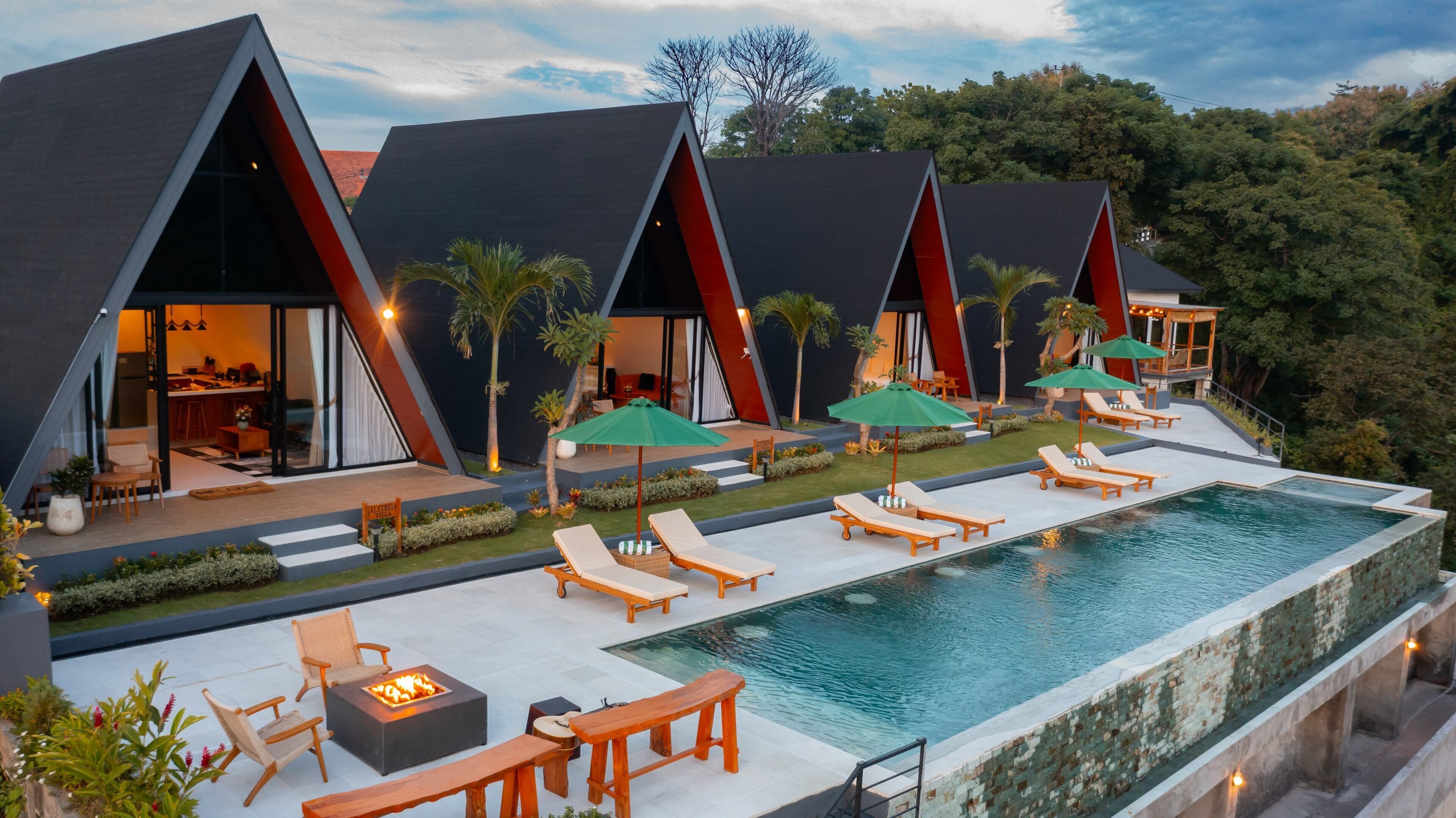 Une villa moderne dotée d’une piscine, d’un espace salon extérieur et offrant une vue sur la forêt environnante.