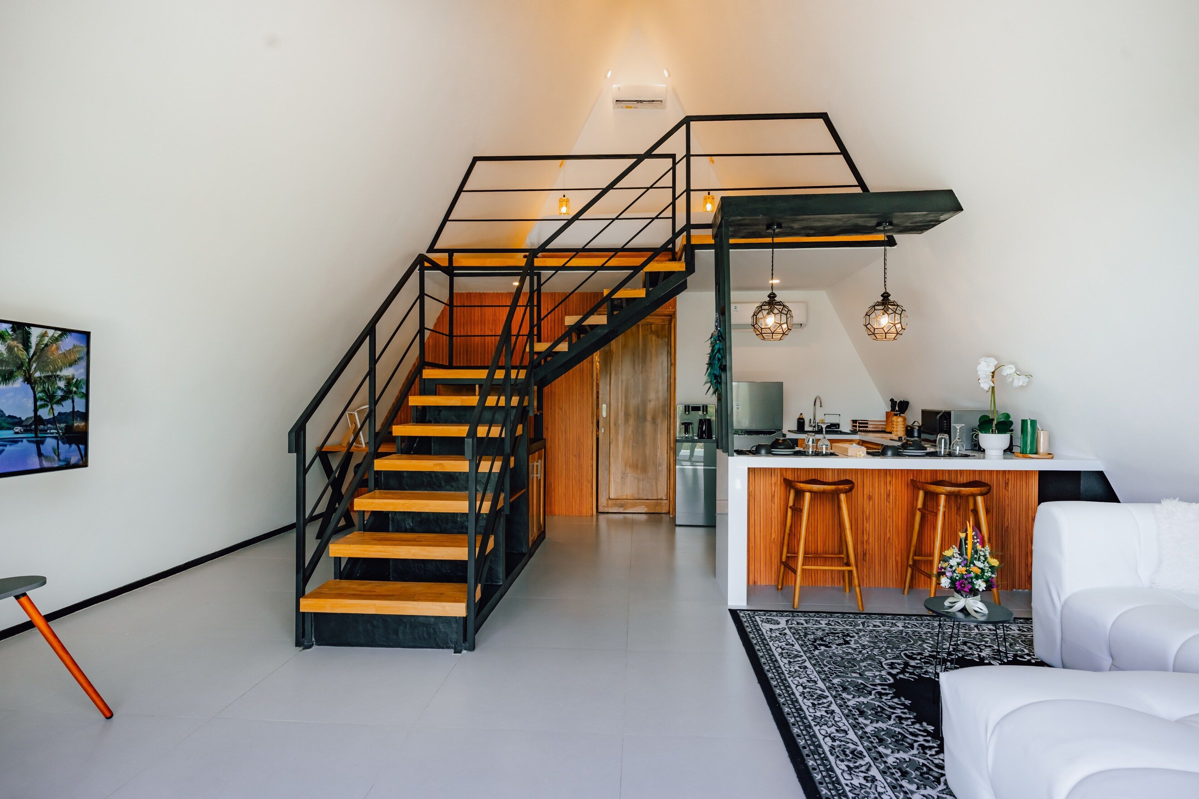 Un intérieur moderne comprenant un escalier, une cuisine et un coin salon.