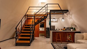 A modern interior with a staircase, kitchen, and living area. - Dream Catcher Villas (Singaraja)