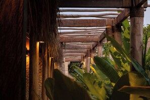 A wooden structure with a thatched roof, surrounded by tropical plants. - Villa Kokomo - 2 Bedroom Villa (Nusa Lembongan)