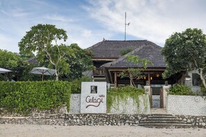 Eine Villa mit Steineingang, einem Reetdach und einem Schild mit der Aufschrift 'villa Celagi'.