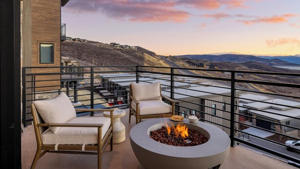 Un balcon doté d’un foyer extérieur, de sièges et offrant une vue sur une vallée.