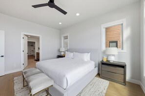 A bedroom with a bed, bedside tables, a bench, a ceiling fan, and a window. - Sauna + Cold Plunge + Game Room | Jordanelle Views | Serenity Now (Hideout)