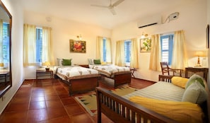 A room with two beds, a desk, a chair, and a ceiling fan. - Isai Karai Bungalow - A CGH Earth Saha (Tirupporur)