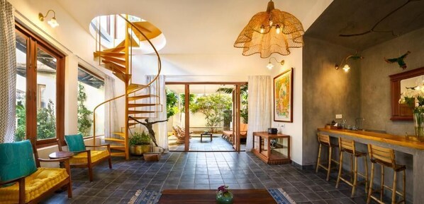 Un interior moderno con una escalera en espiral, una zona de bar y vistas al exterior.