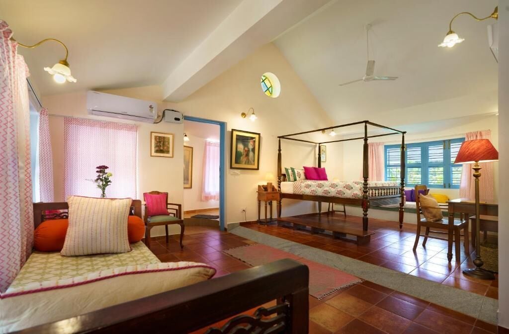A room with a bed, a desk, a chair, a window, and an air conditioning unit.