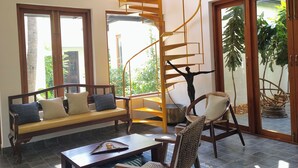 A modern living room with a spiral staircase, a sofa, a coffee table, and a chair.