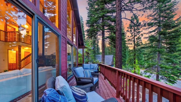 A wooden deck with wicker furniture and a glass door leading to a room. - Forest Views + Wrap Decks | Truckee + Lake Tahoe | Bear's Lair (Truckee)