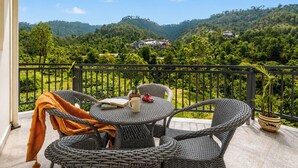 A balcony with wicker furniture, a book, a mug, and a toy car. - Alaya Stays Gable Pine with Pool (Kasauli)