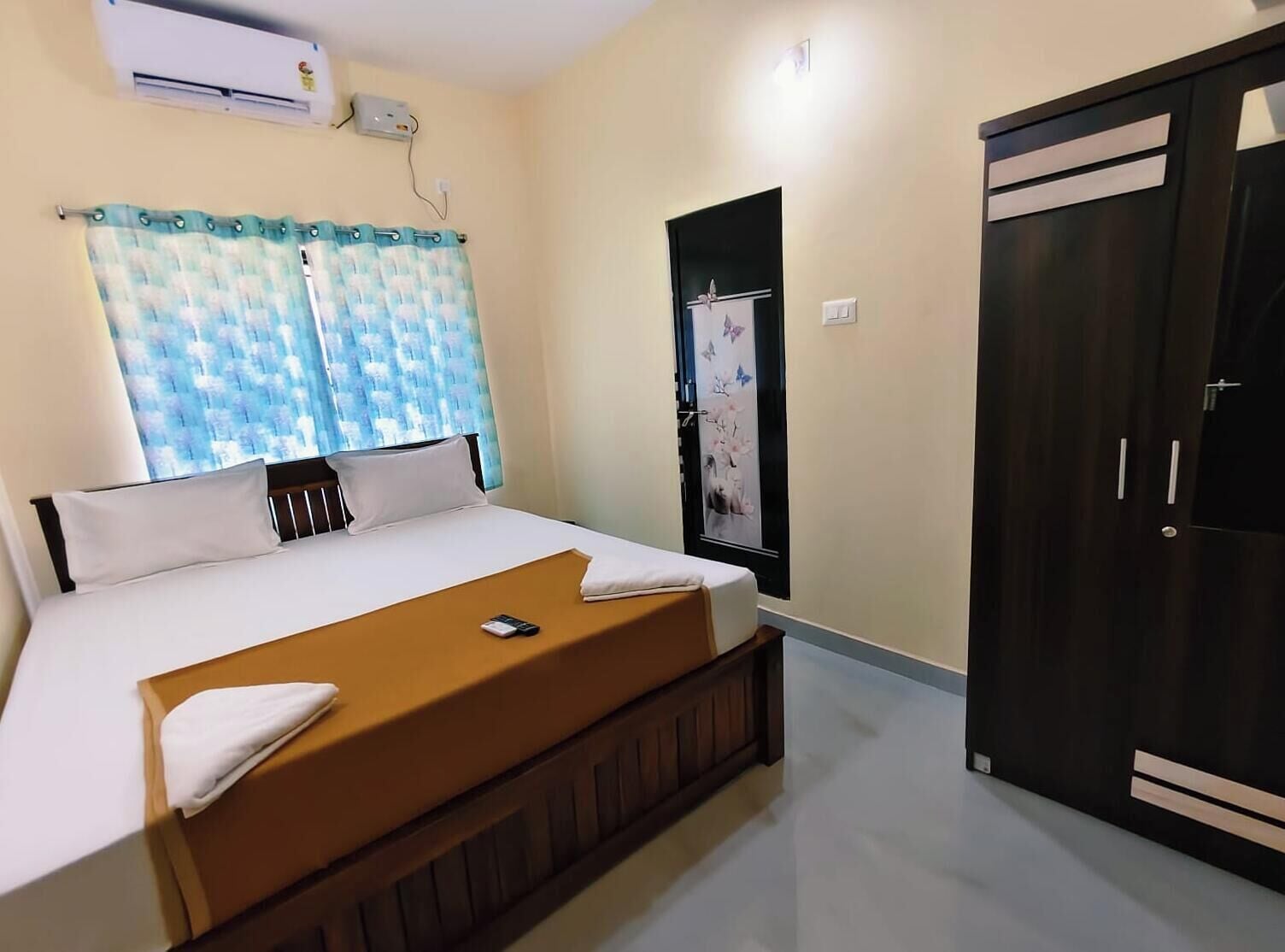 A bedroom with a bed, a wardrobe, and an air conditioning unit.