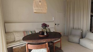 Une pièce chaleureuse avec une table ronde en bois, un canapé et deux fauteuils.