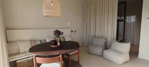 Ein gemütliches Zimmer mit einem runden Holztisch, einer Couch und zwei Sesseln.
