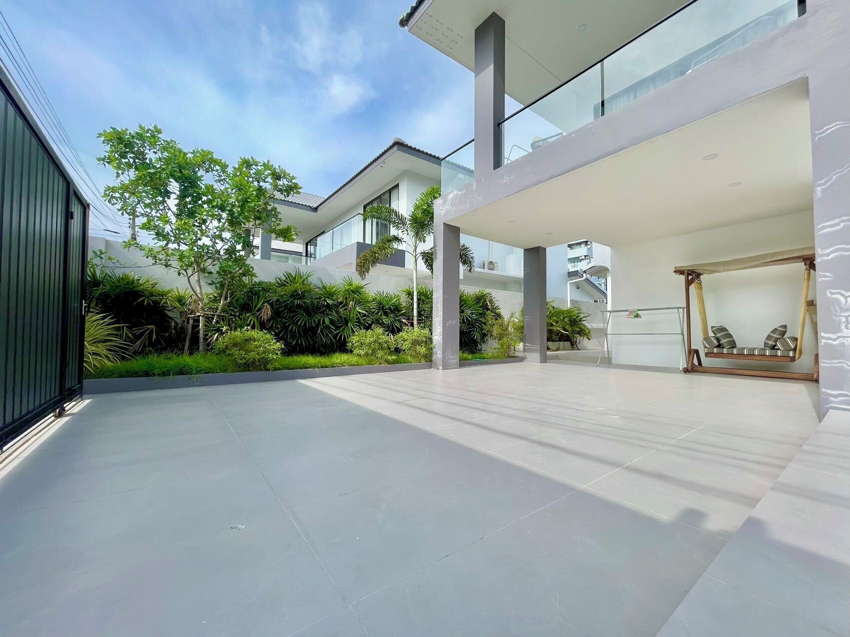 A modern building with a flat roof, large windows, and a covered outdoor seating area.