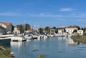 Ein Yachthafen mit mehreren dort vertäuten Booten, umgeben von Gebäuden mit roten Ziegeldächern.