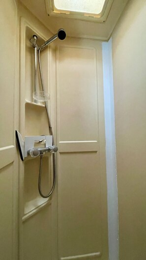Een douche met een handdouche en een slang.