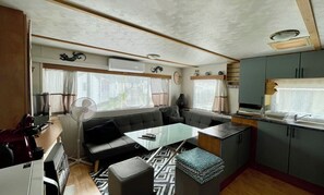 Een compacte camperinrichting met een kitchenette, eethoek en zithoek.