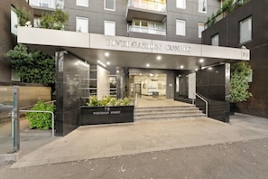 Exterior dos Condomínios Rivergarden, com entrada moderna incluindo porta de vidro, escada que leva à entrada e placa com o endereço 79 Whiteman Street.