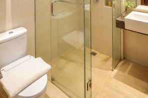 A modern bathroom with a glass-enclosed shower, a white toilet, and a marble countertop with a sink.