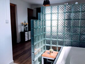 A room with a glass partition, a small wooden table with a vase, and a bed. - Serene 3-Bedroom Villa with Private Pool in Roches Noires (Roches Noires)