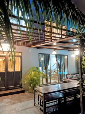 An outdoor seating area with a table and benches, surrounded by plants and a covered structure. - Serene 3-Bedroom Villa with Private Pool in Roches Noires (Roches Noires)
