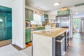 A kitchen with green cabinets, a wooden island, stainless steel appliances, and a view to the outside. - 5 Mi to Soccer Stadium! Zen Retreat in North Miami (North Miami Beach)