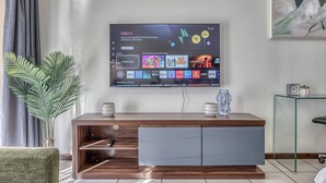 Un televisore a schermo piatto montato a parete mostra l'interfaccia di un servizio di streaming.