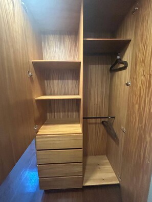 A wooden closet with multiple drawers and shelves.