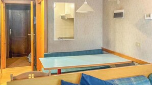A room with a wooden bench, a sofa with blue cushions, a hanging light fixture, and a mirror on the wall. - La Grand'Ourse (Breuil-Cervinia)