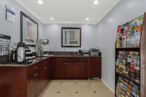 A kitchen with a coffee machine, a framed picture on the wall, and a bookshelf with magazines. - 2 Queen Beds|Suite,Micfridge (Carlsbad)