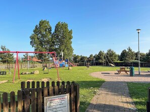 Ein Spielbereich für Kinder mit Schaukeln und einem Picknicktisch.