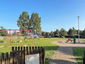Ein Spielbereich für Kinder mit Schaukeln und einem Picknicktisch.