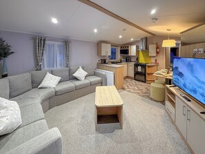 A modern living room with a sofa, a small table, and a TV. - Golf Village 107 - UKC9578 (Mablethorpe)
