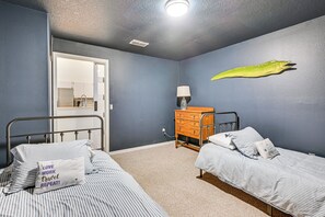 Ein Schlafzimmer mit zwei Betten, einem Schminktisch, einer Lampe und einer Wanddekoration.