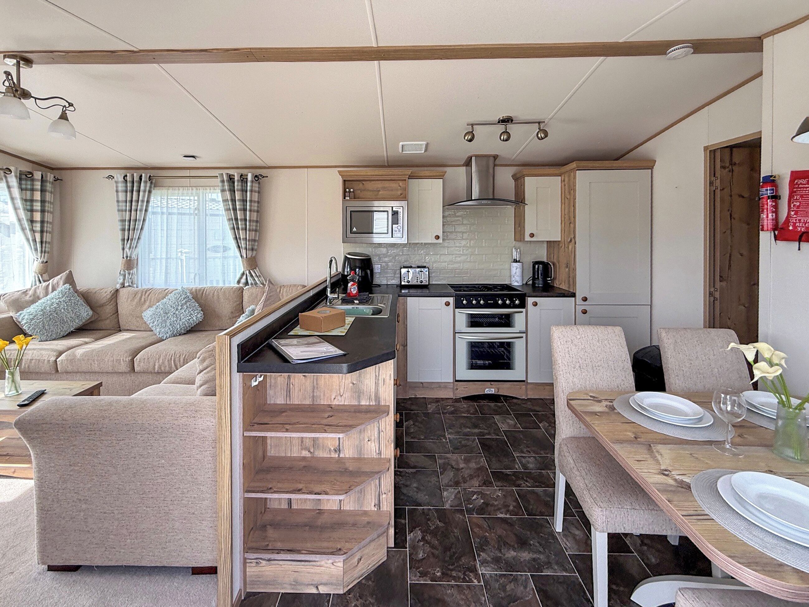 A compact living space with a kitchenette, a dining area, and a sofa.