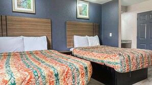 Two single beds with matching headboards, a wooden nightstand, and a door to the right.
