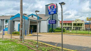 A Relax Inn hotel with a sign indicating low rates and new rooms.