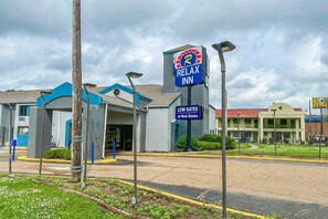 A Relax Inn hotel with a sign indicating low rates and new rooms.
