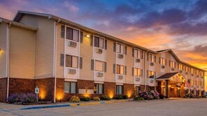 A multi-story hotel with a brick facade, multiple windows, and a parking lot.