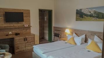 Une chambre d’hôtel avec un lit, un bureau, une chaise, une télévision et un tableau au mur.