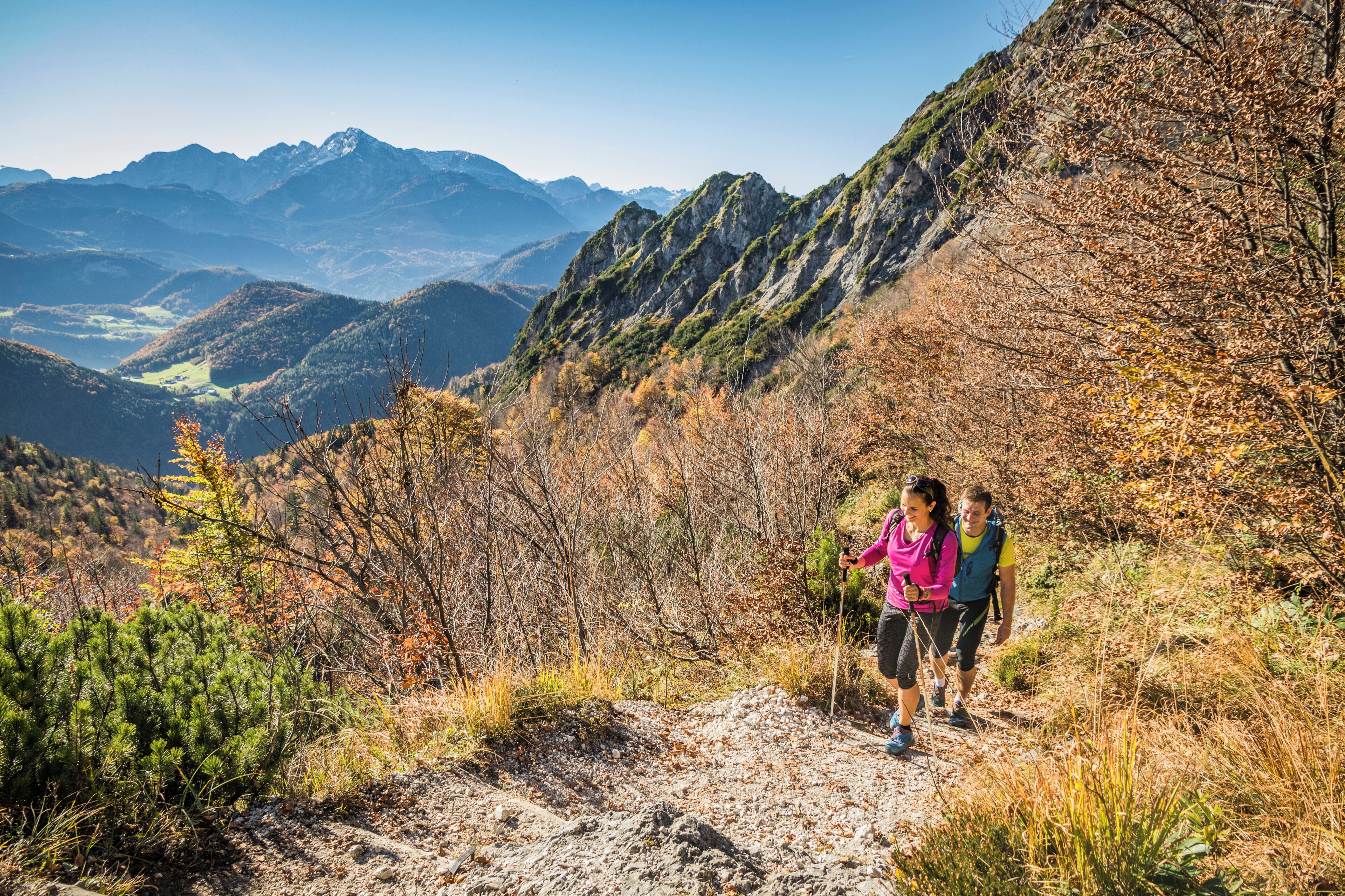 Un sentier de randonnée en montagne, avec un terrain rocheux et une végétation clairsemée.