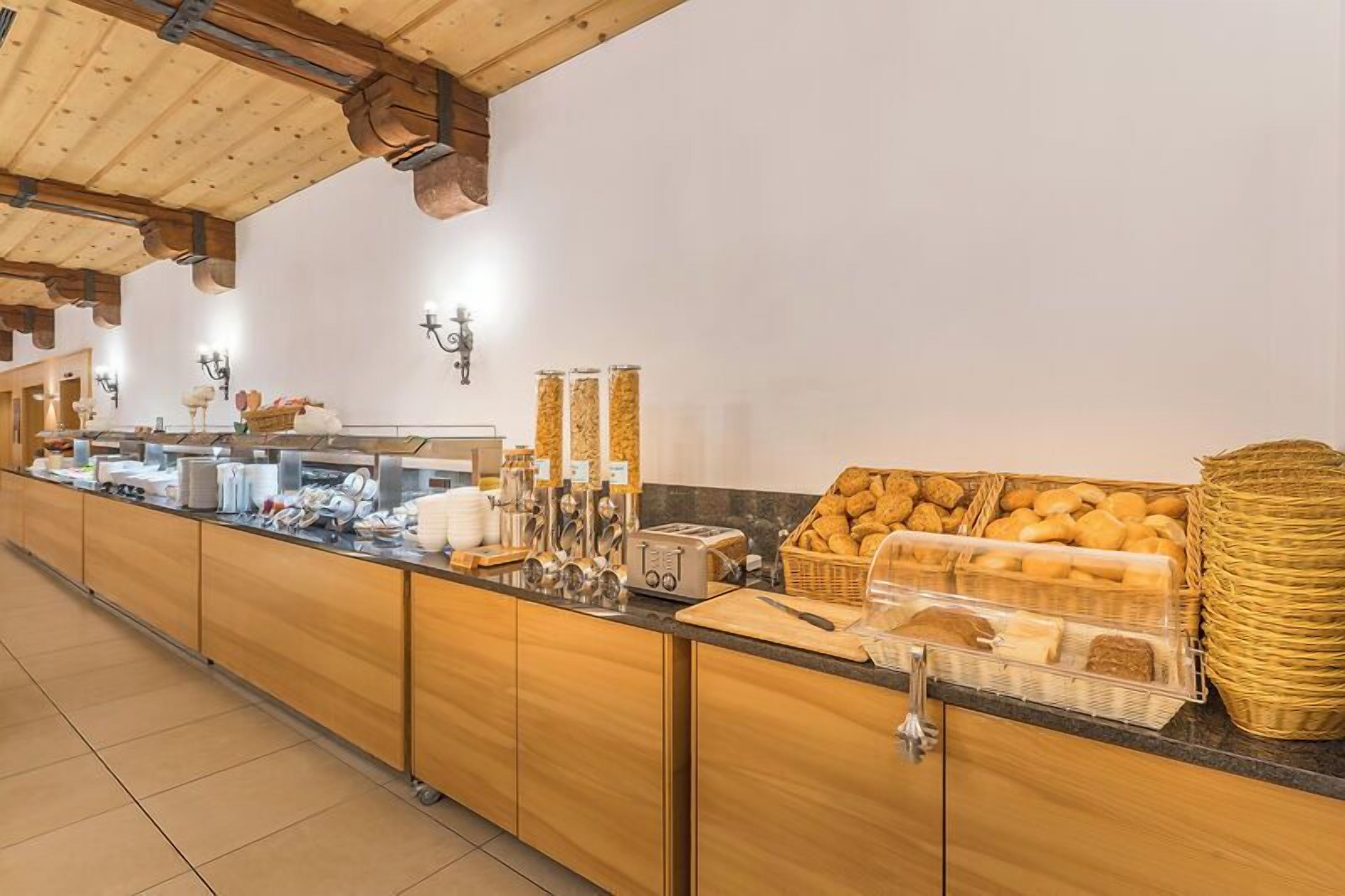 A buffet setup with various food items, a counter, and a wooden cabinet.