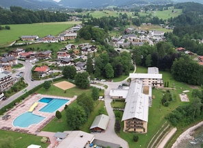 Zona residencial con piscina, varios edificios y una carretera.