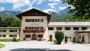 Un bâtiment sur lequel on peut lire l’inscription « Hôtel Duberti », une cour intérieure de forme circulaire et une chaîne de montagnes en arrière-plan.