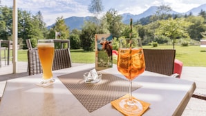Une table avec deux verres contenant des boissons, une assiette et un petit cendrier portant un numéro.