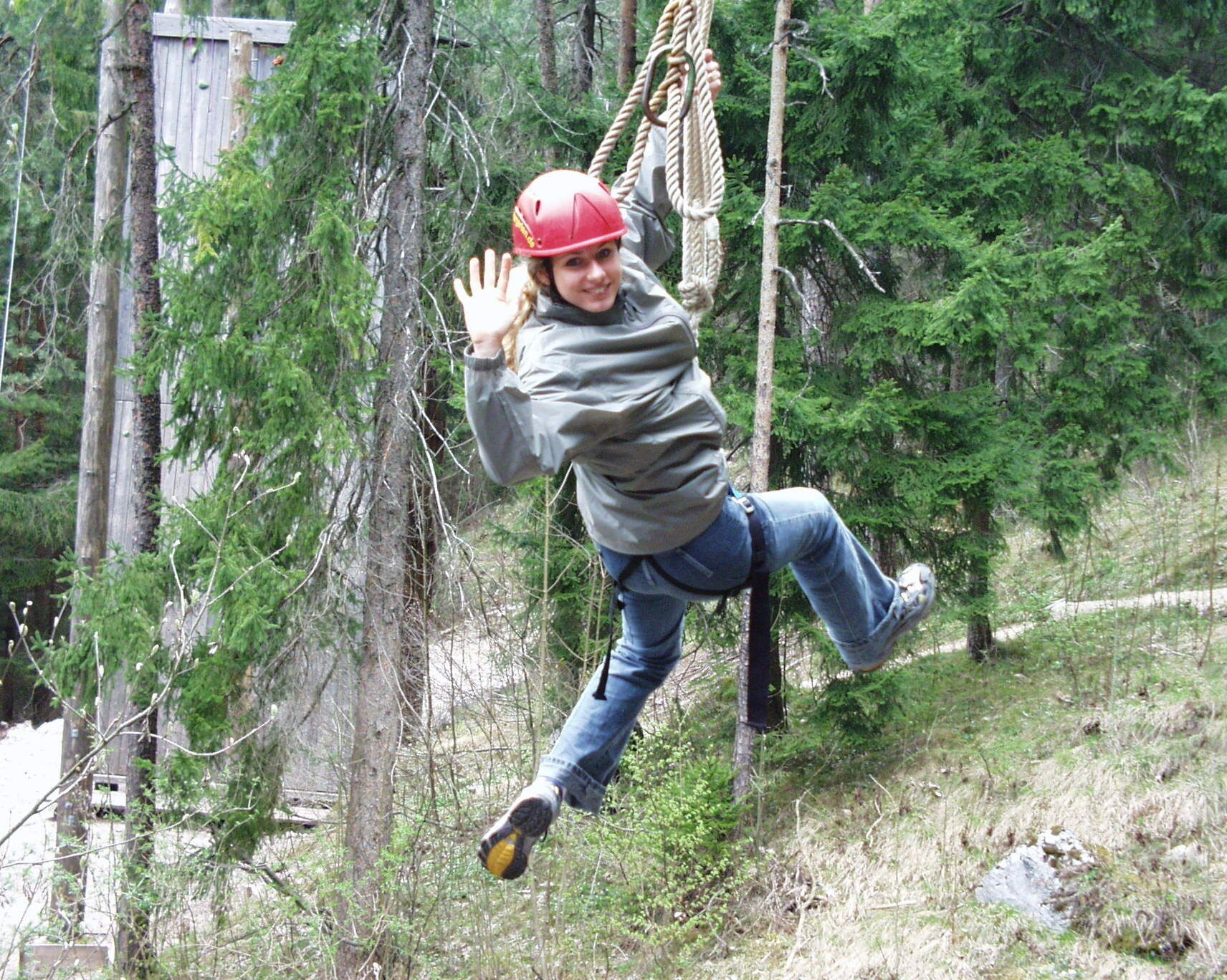 A person in a forested area with a rope swing.