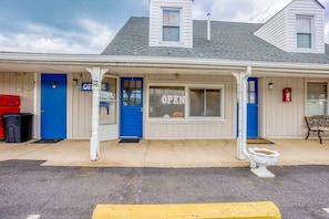 A building with a blue door, a window with 'OPEN' sign, and a bench outside. - 2 Queen Bed|Smk|Natural Bridge (Natural Bridge, VA)