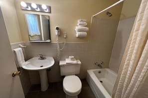 Een badkamer met een wastafel, toilet en bad.