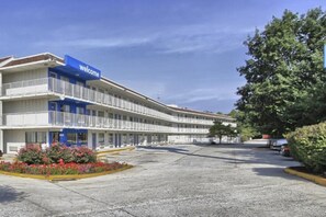 Un motel con un cartello 'Welcome', diversi balconi e un parcheggio.