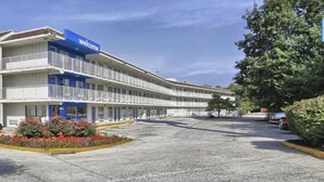 A motel with a 'Welcome' sign, multiple balconies, and a parking lot. - Queen Bed|Non-Smoking (New Cumberland, PA)