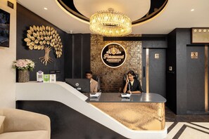 A reception desk with a chandelier, a wall-mounted sign for Paramount Residency, and a 'No Entry' sign.